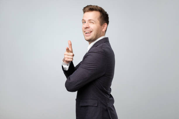Young caucasian man in suit pointing at camera like saying You are right dude Attractive young caucasian man in suit pointing at camera like saying You are right dude young man wink stock pictures, royalty-free photos & images