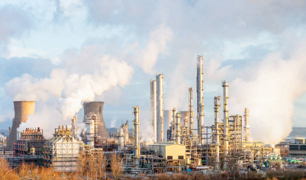 Oil Refinery and Petrochemical Plant at Grangemouth in Scotland Steam and smoke rising from distillation towers and cooling towers towards the left at Grangemouth oil refinery and petrochemical plant in Central Scotland. refinery photos stock pictures, royalty-free photos & images