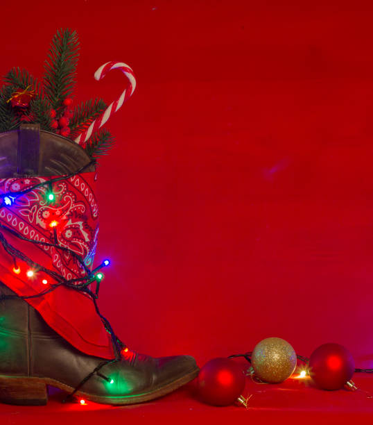 American West traditional cowboy boot and bandanna on christmas red background for text