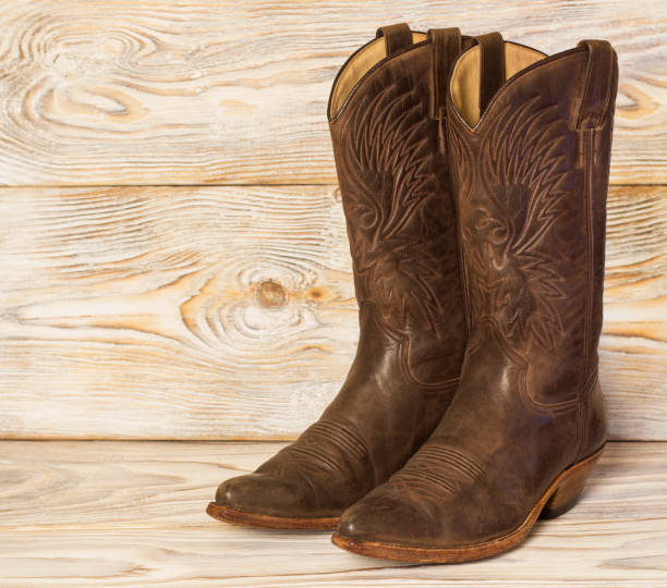 istock Leather cowboy boots on wood background 1045986460