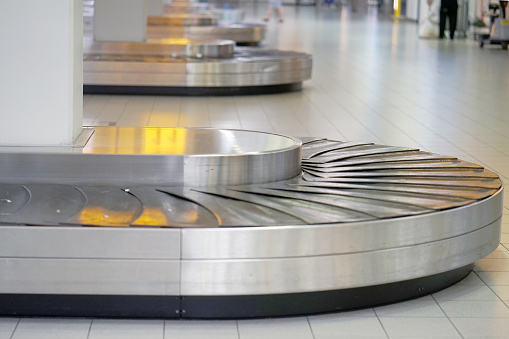 Empty airport baggage belt. Baggage claim area in the airport, abstract luggage line. Selective focus.