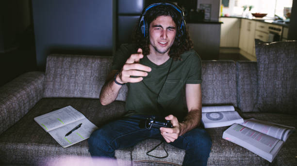 istock Student playing video game sitting at home 1045990824