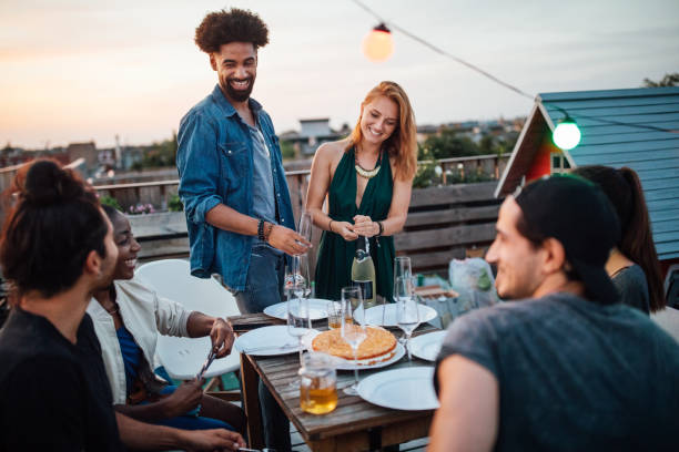 istock Woman opening a champagne at rooftop party 1045996562