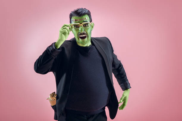 Bloody Halloween theme: The crazy maniak face on studio background Bloody Halloween theme: The crazy maniak face on pink studio background halloween costume stock pictures, royalty-free photos & images