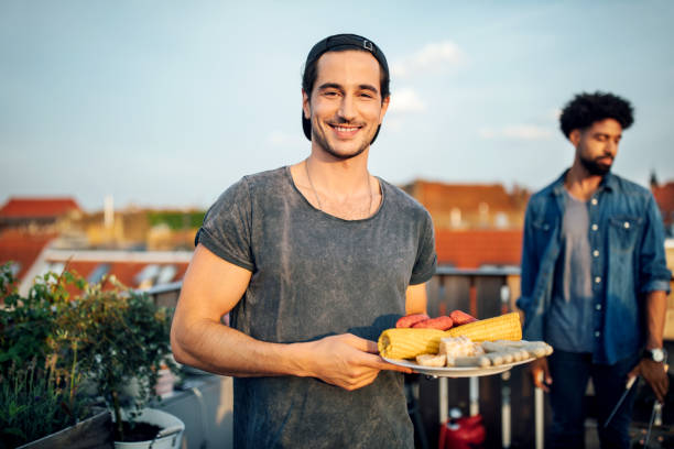 istock Man at reunion barbecue party on rooftop 1045997294