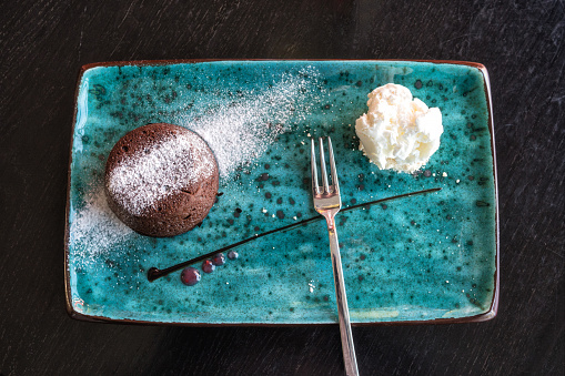 Tasty petit gateau dessert, chocolate fondant or lava cake with vanilla ice cream on the ceramic plate, top view