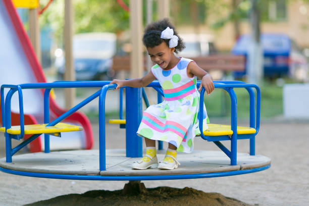 una muchacha negra está en un carrusel. - carousel merry go round child african descent fotografías e imágenes de stock