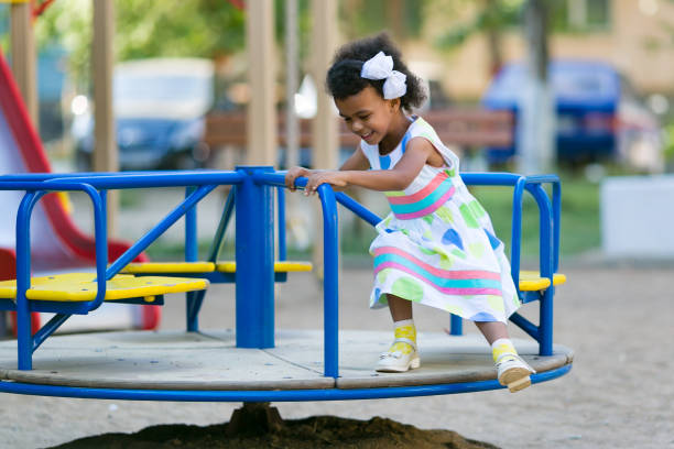istock A black girl is riding a carousel. 1046012528