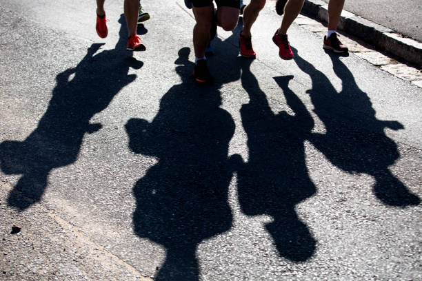 istock Shadows of runners on the road 1046012652