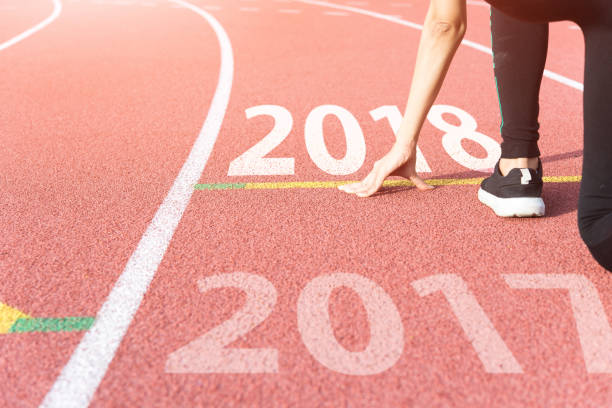 istock Athlete on Starting line waiting for the start in running track with text 2017 year, Start to new year 1046017048