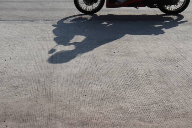 istock silhouette of a motorcycle driver on a cement road 1046020696