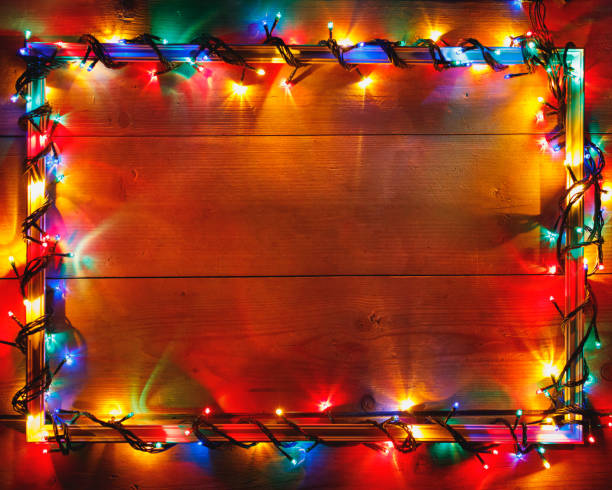 istock Christmas lights frame on wooden background 1046027786