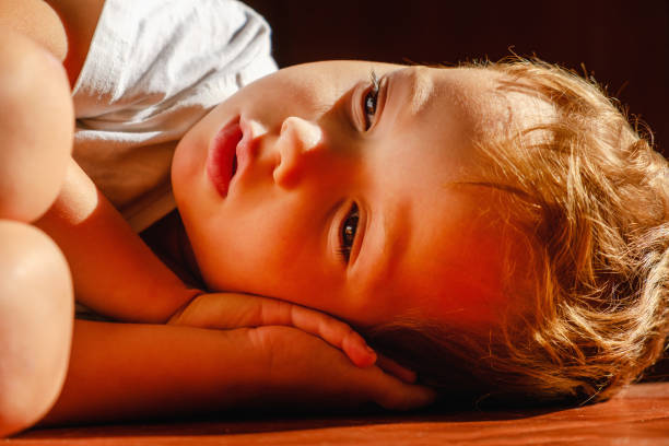 Adorable caucasian little boy sleeping in morning sun beam