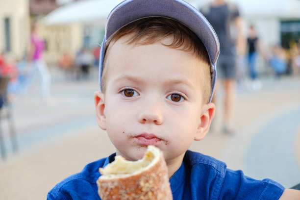 istock Eating the roll is a real pleasure for boy. Weekend, child in park. 1046028232