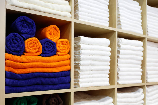 istock Fresh White and colorful Hotel Towels Folded and Stacked on a Shelf 1046056456