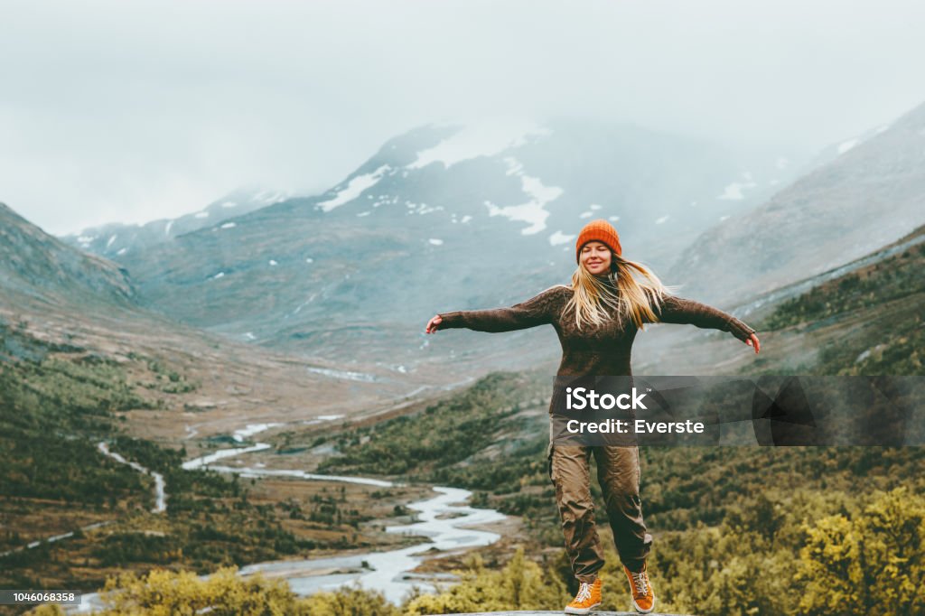 Woman bliss emotional raised hands foggy mountains on background Travel Lifestyle wellness concept adventure  vacations outdoor harmony with nature Jotunheimen park in Norway Women Stock Photo