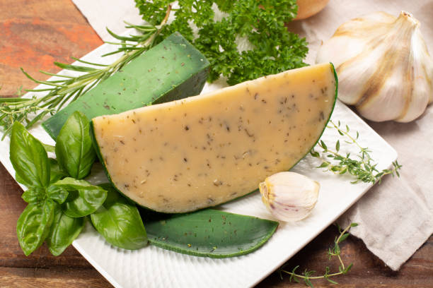 fromage à pâte dure spécialité néerlandaise fait de lait de vaches avec différentes épices et herbes vertes fraîches - basiron photos et images de collection