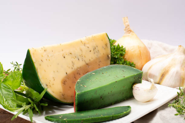 fromage à pâte dure spécialité néerlandaise fait de lait de vaches avec différentes épices et herbes vertes fraîches - basiron photos et images de collection