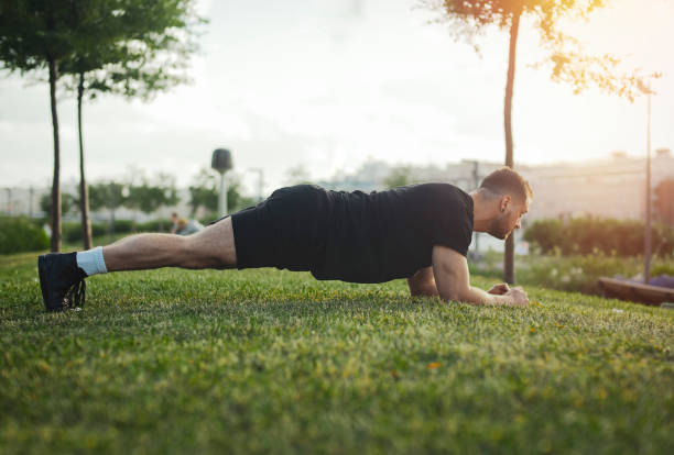 istock Distant plan of young attractive man exercising plank outdoors. 1046075838