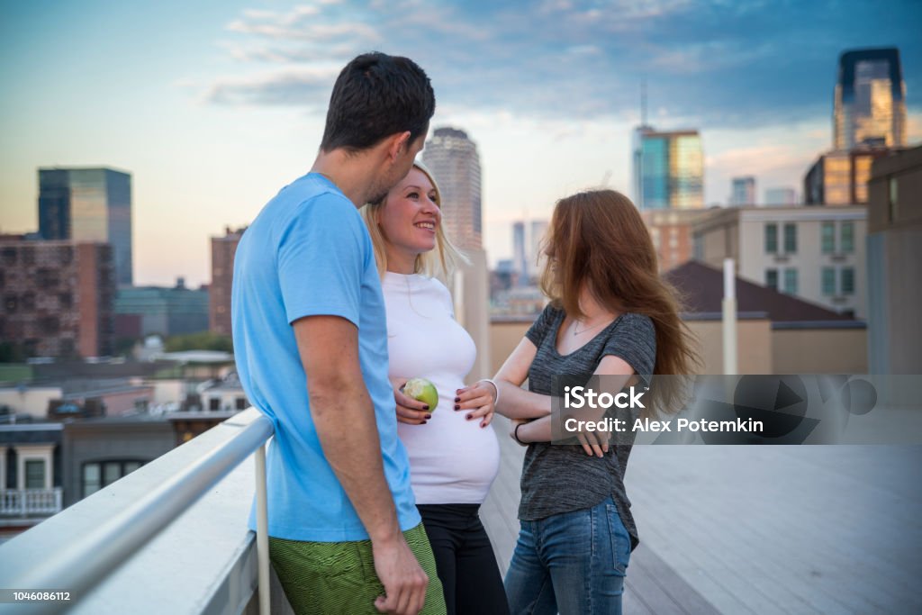 La jeune mariée caucasienne famille blanche, l’homme et la femme enceinte avec sa petite soeur, la fille d’adolescent âgé de 16 ans, traîner ensemble et s’amuser sur le toit - Photo de 16-17 ans libre de droits