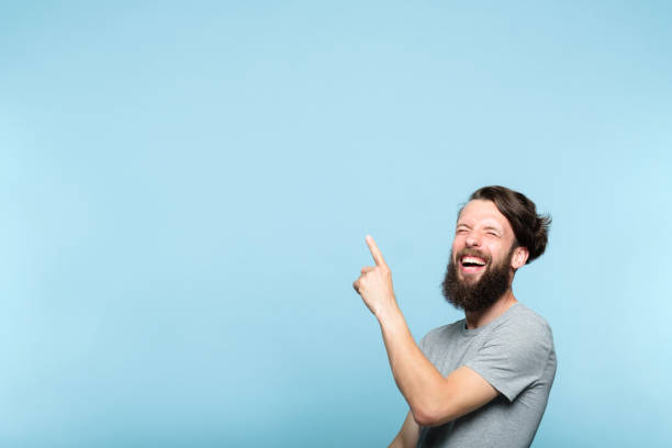 istock laughing man point advertising bearded hipster 1046086910