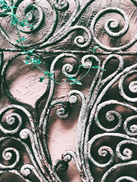 istock Branch growing in metal scrolls on the wall. 1046101720