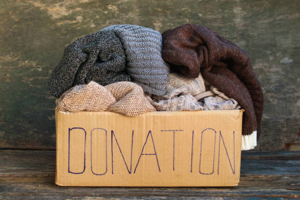istock Donation box with warm things on old wooden background. 1046113066