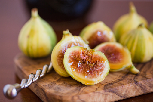 Tiger Stripe Figs drizzled in rich dark organic honey on top of an olive wood cutting board.\n\n‘Panache Tiger Fig’ is a paragon of beauty and taste. Fig tree’s delicious small-to-medium-sized green fruits are beautifully patterned with yellow tiger stripes. Scrumptious fruits, with aromatic, highly flavorful blood-red flesh, make for fine fresh eating; add nectary sweetness to salads and cereals; and, partnered with fresh quince, is the stuff of which superb jams and pies are made.