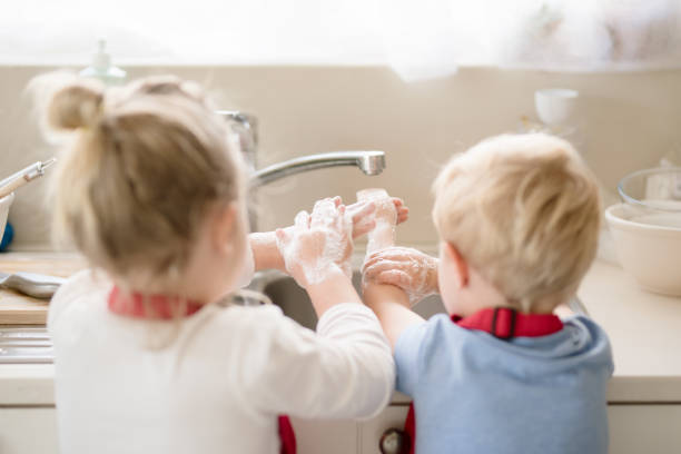 washing up at the kitchen sink - washing hands hygiene human hand faucet imagens e fotografias de stock