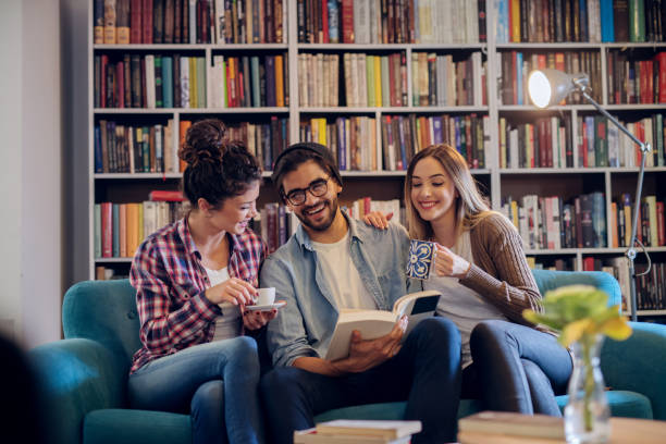 istock Group of three young students sitting in modern library and taking a break from hard learning. Preparing exams together. 1046125494
