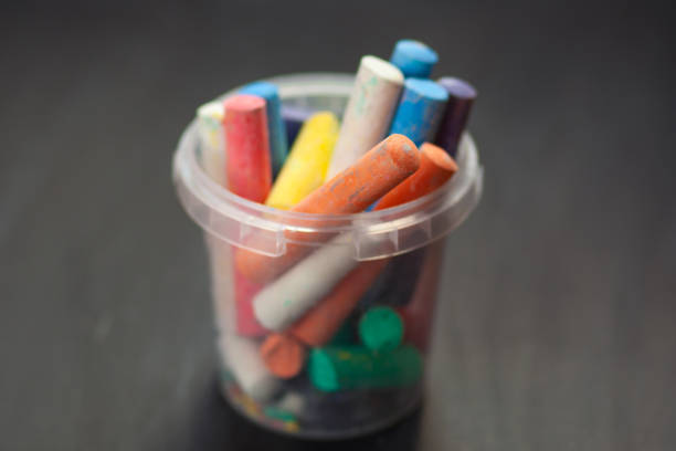 istock Color chalk in plastic cans closeup on blackboard. Selective focus 1046136648