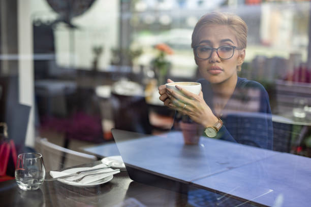 istock Young asian female student drinking tea in restaurant. 1046139332