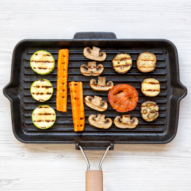 istock Grilled vegetables in a grilling pan on a white wooden table, overhead view. From above, flat lay, top view. 1046144238