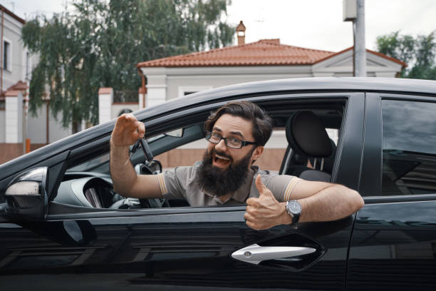 istock Charismatic man holding car keys showing thumbs up 1046145392