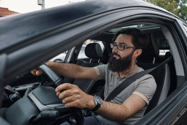 istock Modern casual bearded man driving a car 1046145410