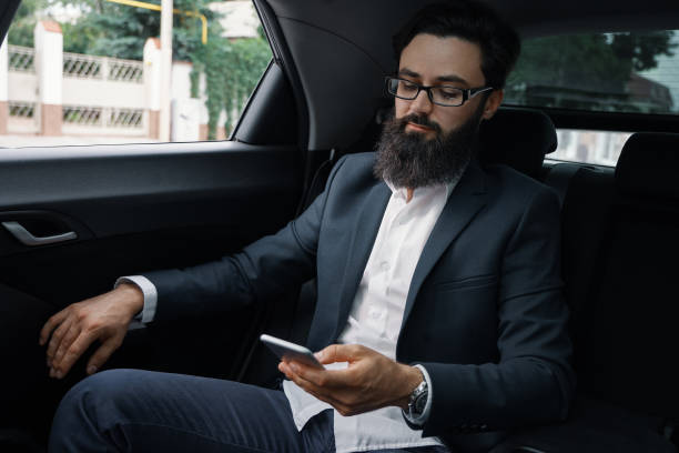 istock A businessman while traveling by car in the back seat using a smartphone 1046145448