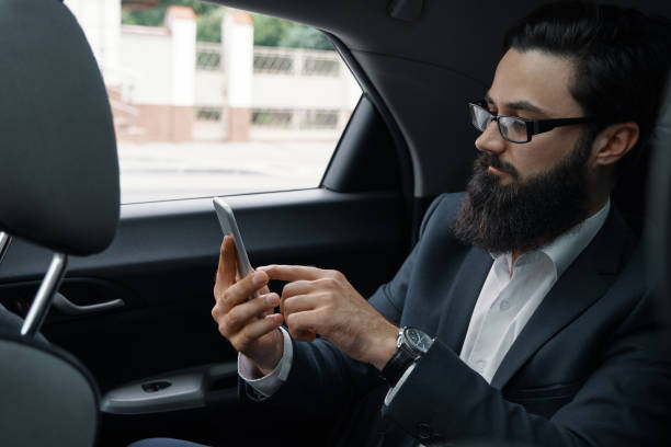 istock A businessman while traveling by car in the back seat using a smartphone 1046145458