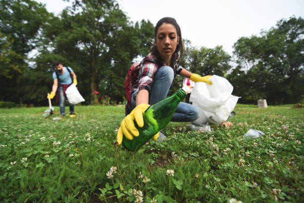 giovani volontari raccolgono immondizia in un parco pubblico - trash day foto e immagini stock