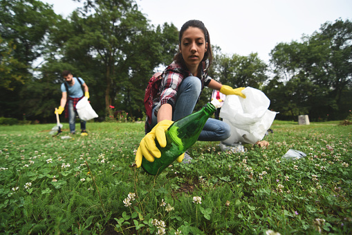 A group of young volunteers help collecting garbage in a public park