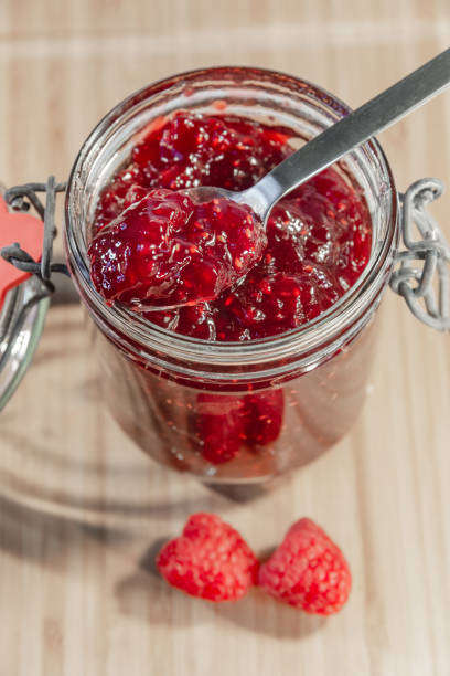 istock Red raspberry jam in glass and fresh raspberries with a spoon 1046150068