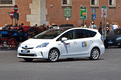 Rome, Italy - 1st June, 2018: Hybrid minivan Toyota Prius Plus in taxi version driving on the street. The Prius Plus model is popular hybrid minivan in taxi corporations in Europe.