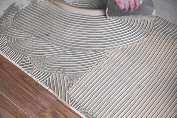 istock Worker applying wooden flooring adhesive 1046156402