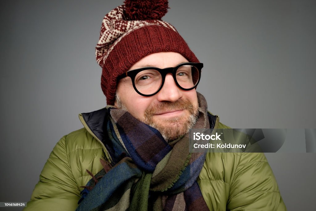 Portrait of a handsome young man smiling wearing warm winter coat, scarf, and funny hat Portrait of a handsome young man smiling wearing warm winter coat, scarf, and funny hat. I am ready for cold winter weather 30-39 Years Stock Photo