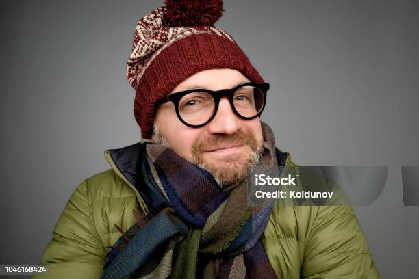 Portrait Of A Handsome Young Man Smiling Wearing Warm Winter Coat Scarf And Funny Hat Stock Photo - Download Image Now