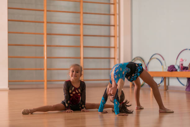 молодые балерины-танцовщицы практикуют в балетной студии. - floor gymnastics стоковые фото и изображения