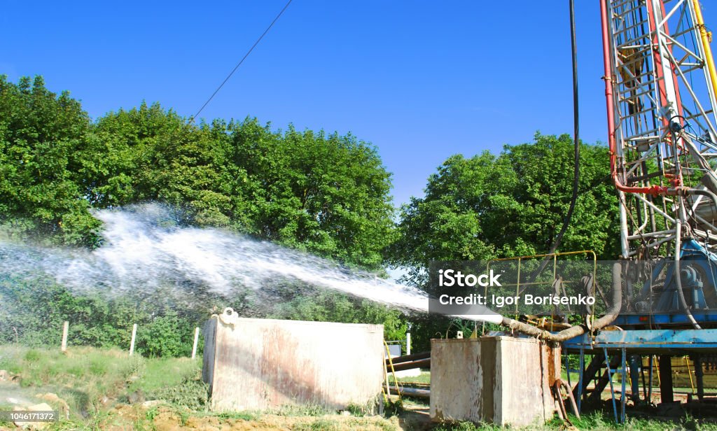 appareil de forage perce un puits pour extraire l’eau. Assimilation bien l’approvisionnement en eau sous pression de roches à la surface - Photo de Puits à eau libre de droits