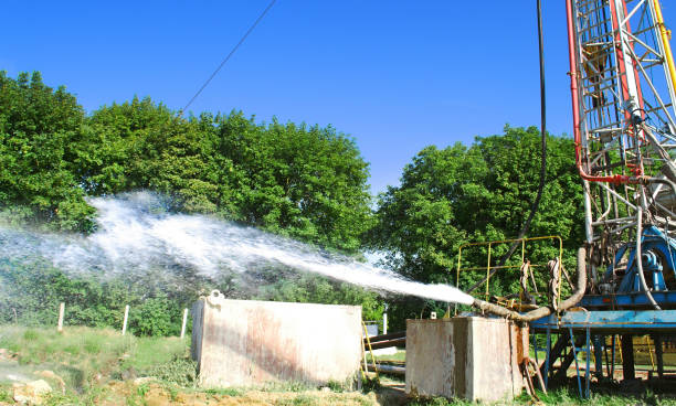 drilling rig drills a well to extract water. well assimilation water supply under rock pressure to the surface - deep of field imagens e fotografias de stock