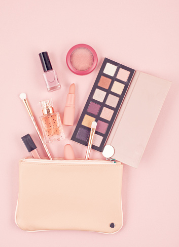 Mockup of makeup cosmetic products over pastel pink background, flat lay, top view. Woman beauty fashion decorative.