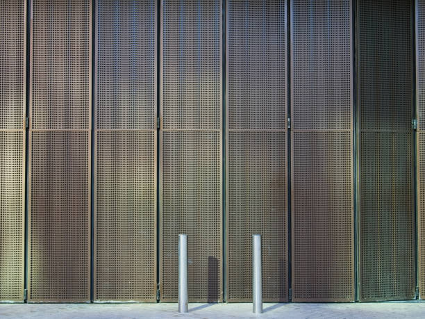 istock Modern metallic mesh folding slide shutter and two sliver metallic street poles. 1046175062