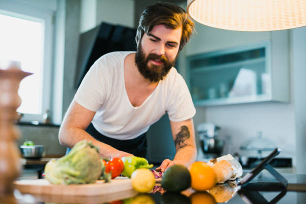 istock Young man preparing healthy meal in the kitchen 1046187264